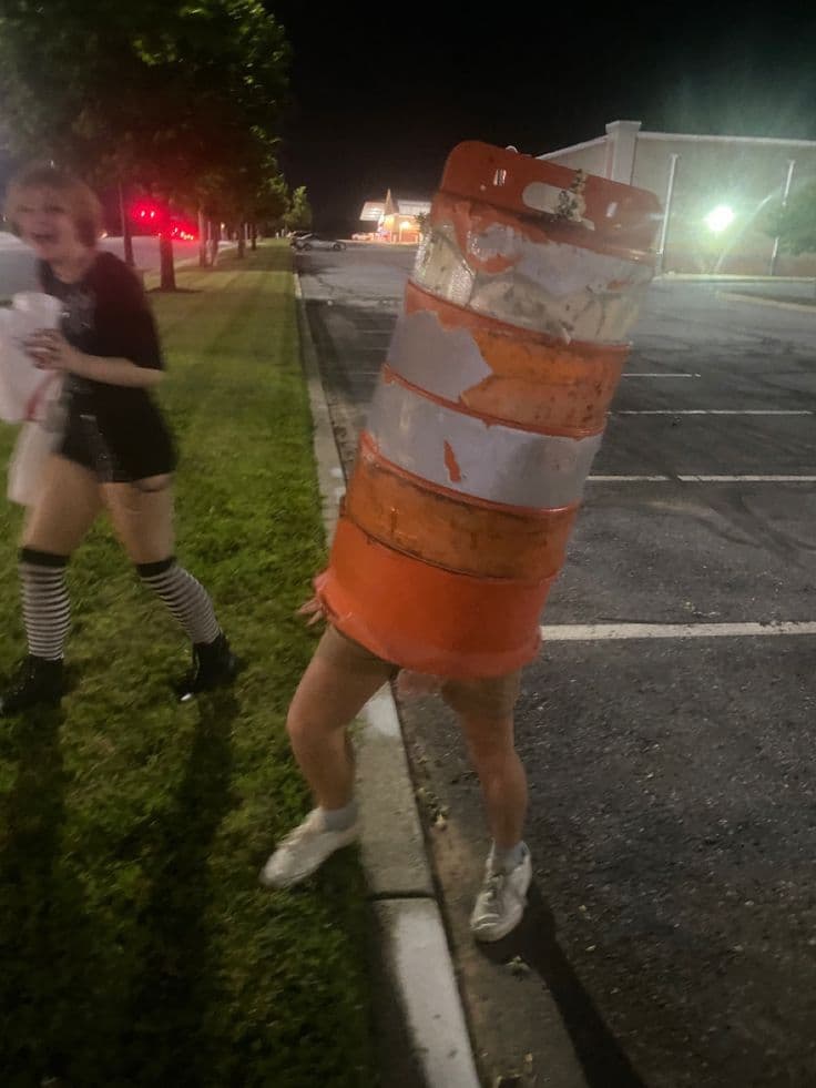 Max wearing a traffic barrel as a hat while a friend laughs